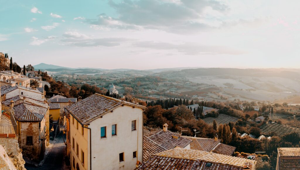 Aerial view of Montone Italy terracotta roofs rolling hills sunlit golden countryside wallpaper