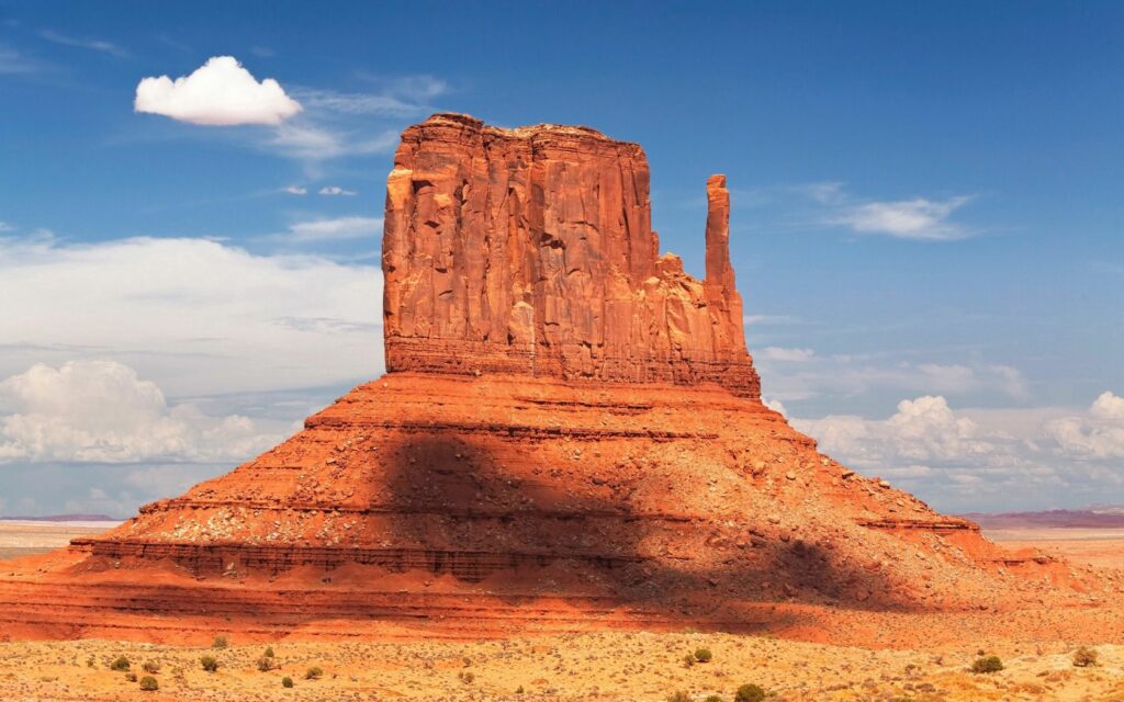 Monument Valley red sandstone cliffs under bright blue sky vast desert classic Southwest landscape Wallpaper