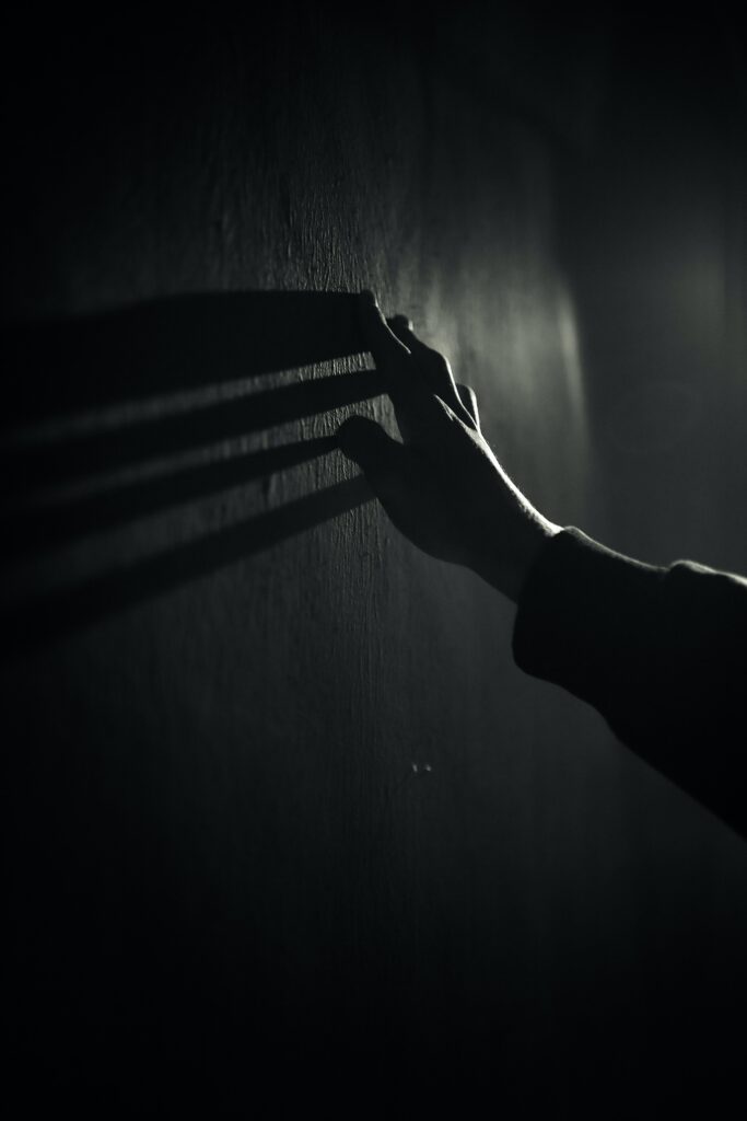 Moody Black and White Wallpaper: Hand Reaching Against Textured Wall