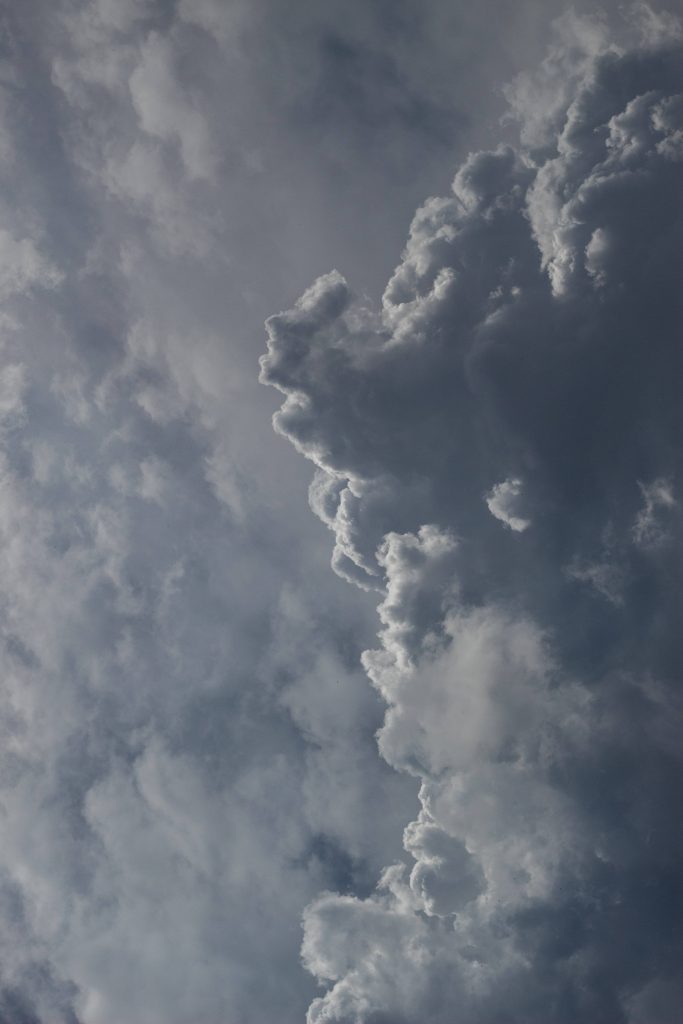 Moody cloud wallpaper with dense white and slate-grey clouds over overcast sky background