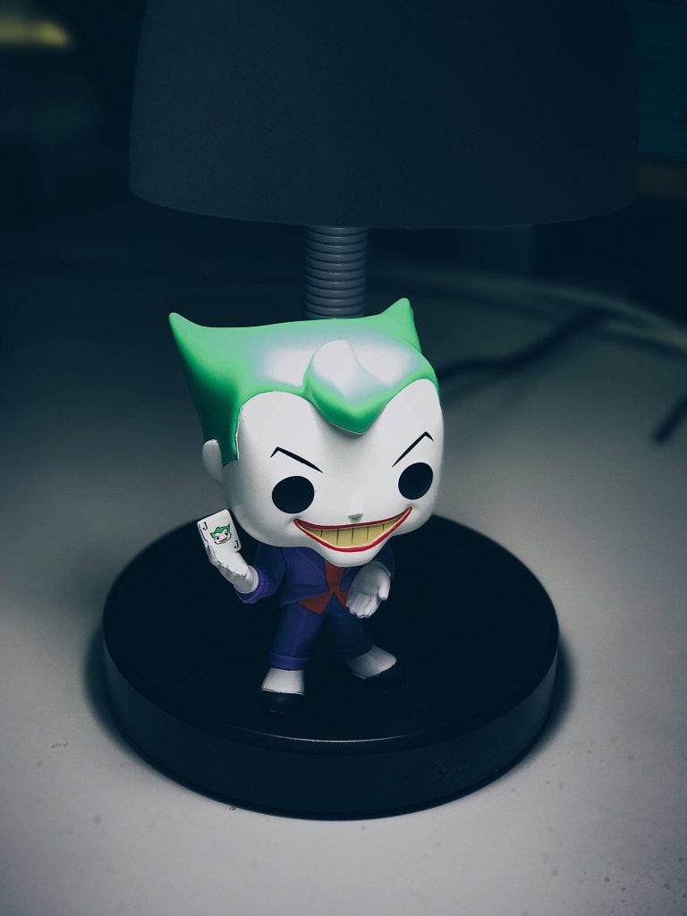 Moody Joker Funko Pop with green hair purple suit on black lamp base DC Comics wallpaper background