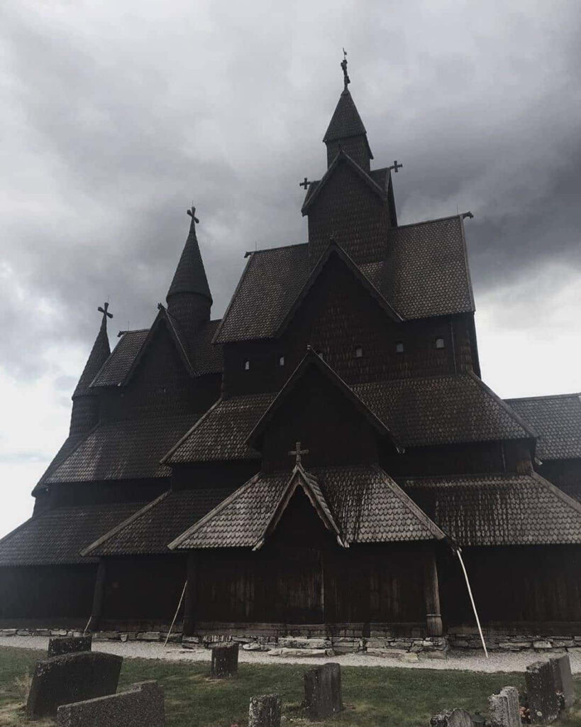 Moody Heddal Stave Church Wallpaper: Intricate Architecture Under Clouds