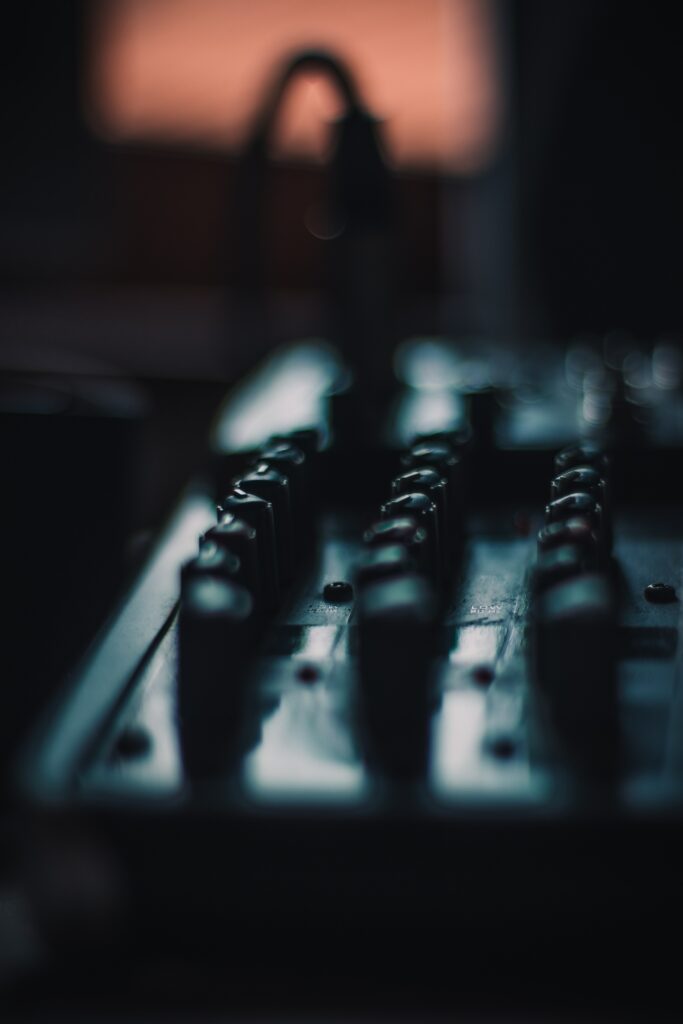 Moody Close-Up of Mixing Console: Artistic DJ Wallpaper Background