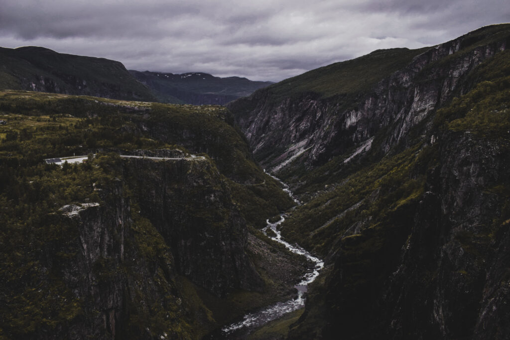 Dramatic landscape wallpaper winding stream dark rugged mountains moody overcast sky textures