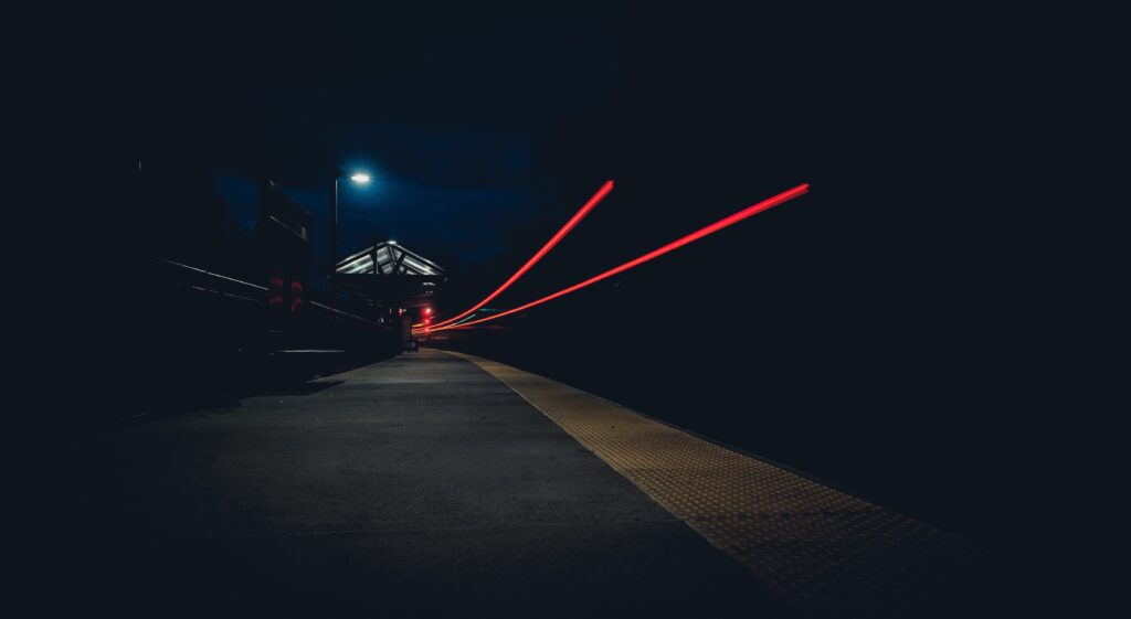 Moody Night Street Wallpaper: Dim Train Platform with Red Light Streaks
