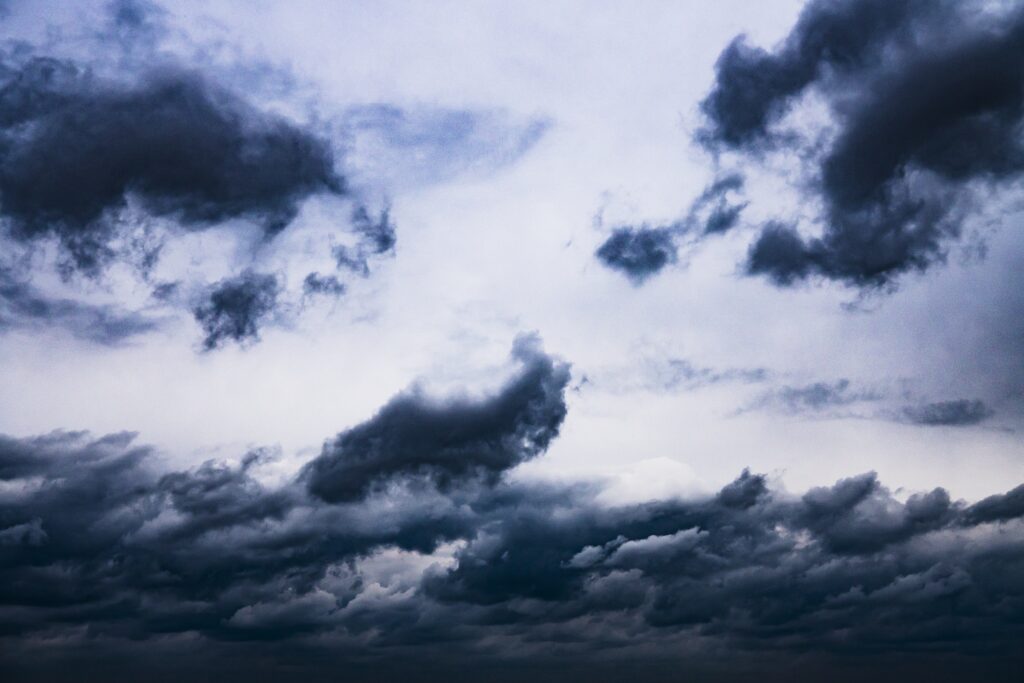 Moody overcast sky with dense gray and blue clouds creating a calm before storm wallpaper