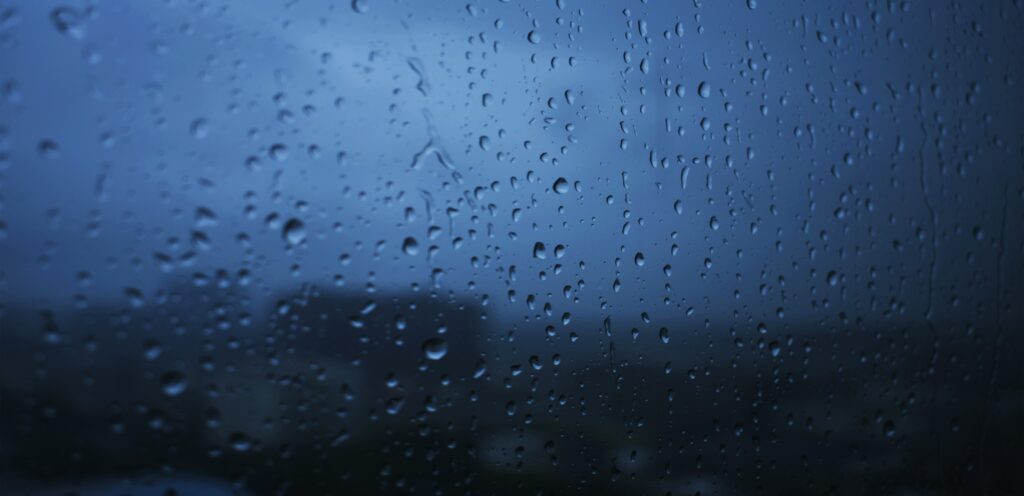Serene Rainy Day Wallpaper: Moody Window with Raindrops Background