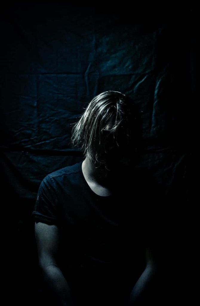 Moody wallpaper of sad man silhouette in dramatic low-key lighting with cool blue tones background
