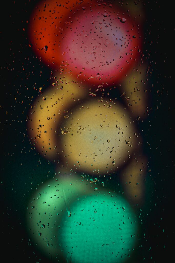 Moody Rain-Speckled Traffic Light Macro: Colorful Wallpaper Background