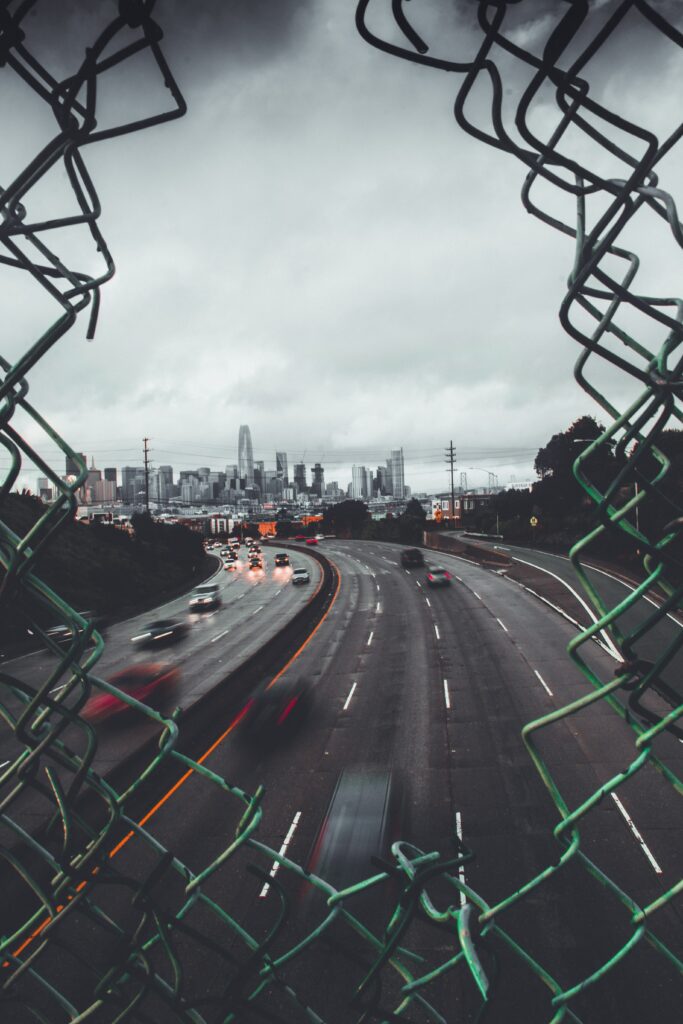 Moody Urban Wallpaper: Cityscape Through Chain-Link Fence