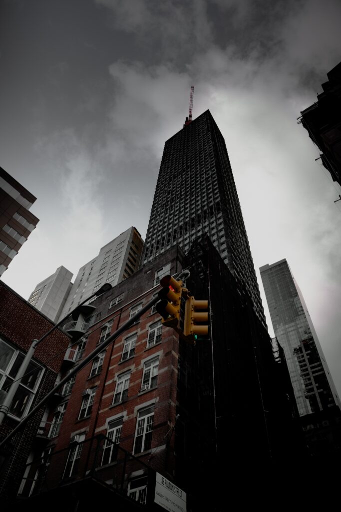“Dramatic Cityscape Wallpaper: Towering Buildings & Moody Sky”