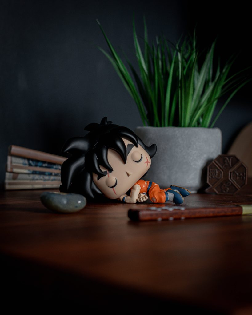 Yamcha Funko Pop in defeated pose on wooden desk with green plant moody Dragon Ball Z wallpaper