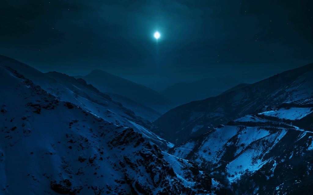 Moonlit snow mountain summit with rugged peaks under starry night sky serene winter wallpaper