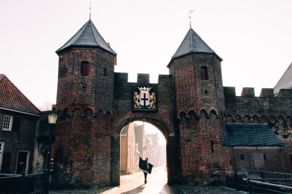 Medieval gate in Amersfoort bathed in soft morning light highlighting historic brickwork and calm Wallpaper