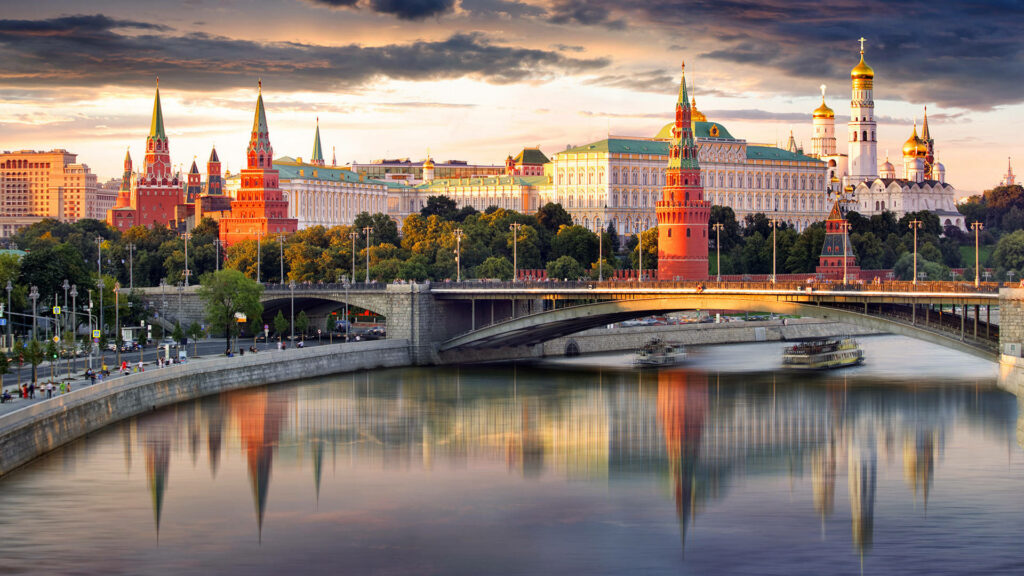 Moscow Kremlin towers and golden domes reflecting in Moskva River at sunset wallpaper background