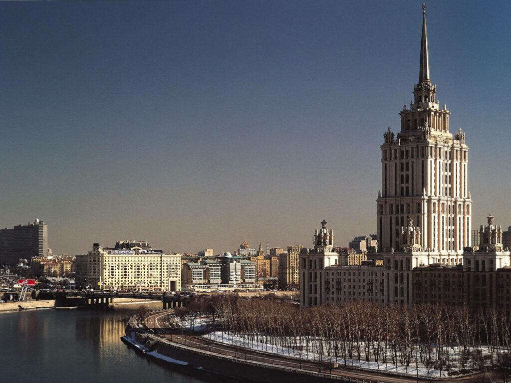 Moscow Radisson Collection Hotel towering over river cityscape on a clear sunny day wallpaper