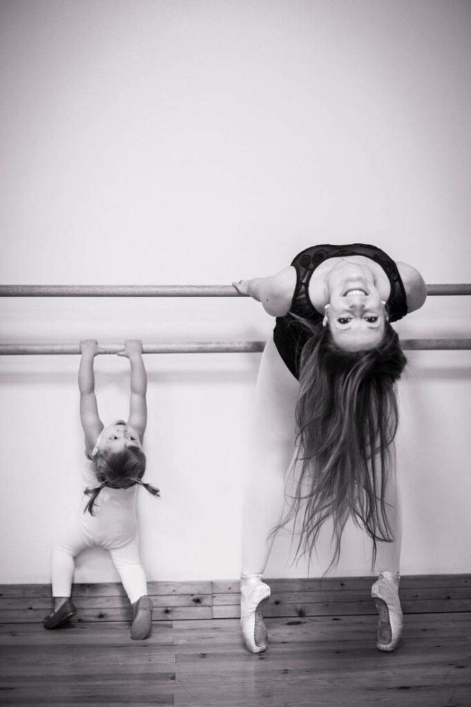 Heartwarming Bond: Mother and Daughter at the Ballet Barre Wallpaper
