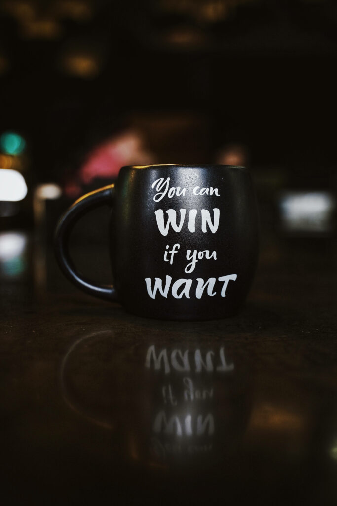 Motivational Wallpaper: Black Mug & Quote on Dimly Lit Background
