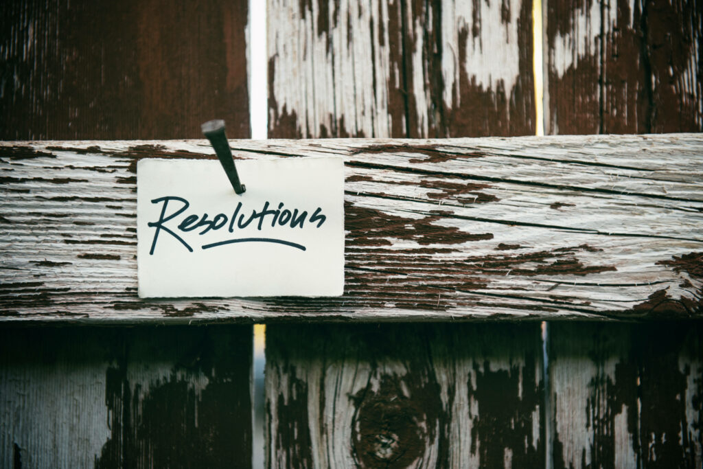 Rustic Wooden Background with Inspiring 'Resolutions' Sign Wallpaper