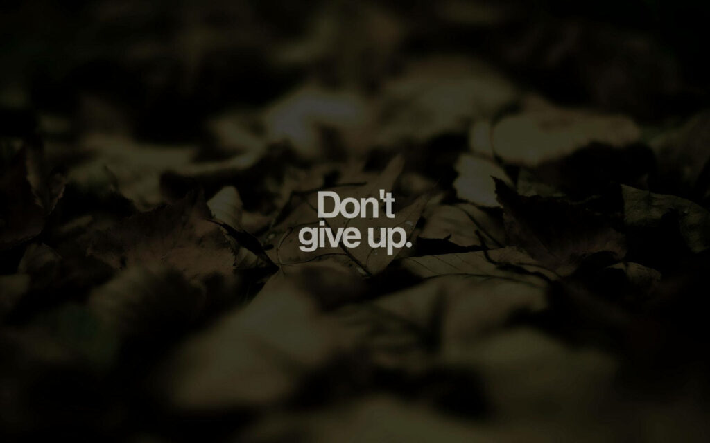 Motivational Don't Give Up Wallpaper with Blurred Earthy Leaves