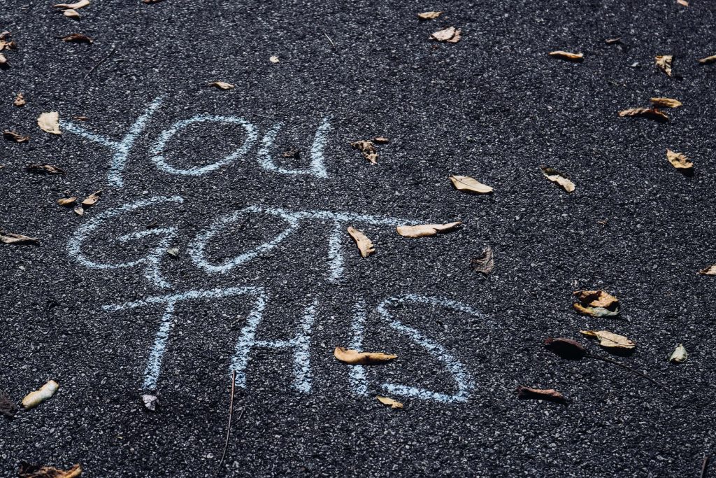 Motivational You Got This blue chalk text on rough concrete with dried leaves urban wallpaper