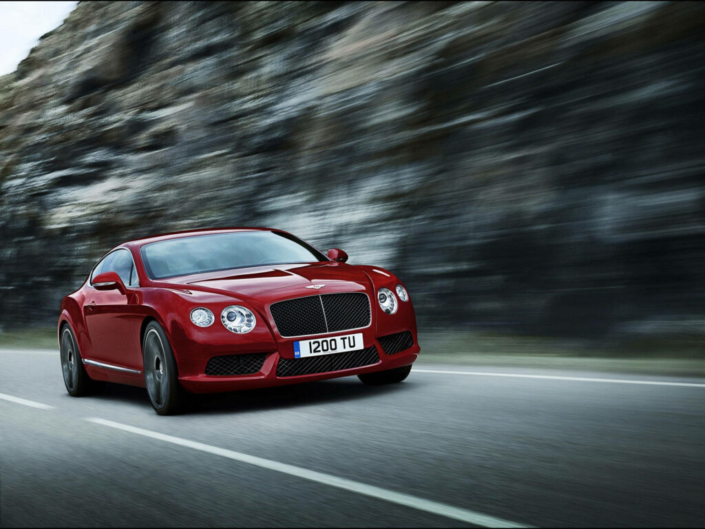 Fast and Furious: Red Bentley Continental GT Zooms across Mountain Landscape with Motion Blur Wallpaper