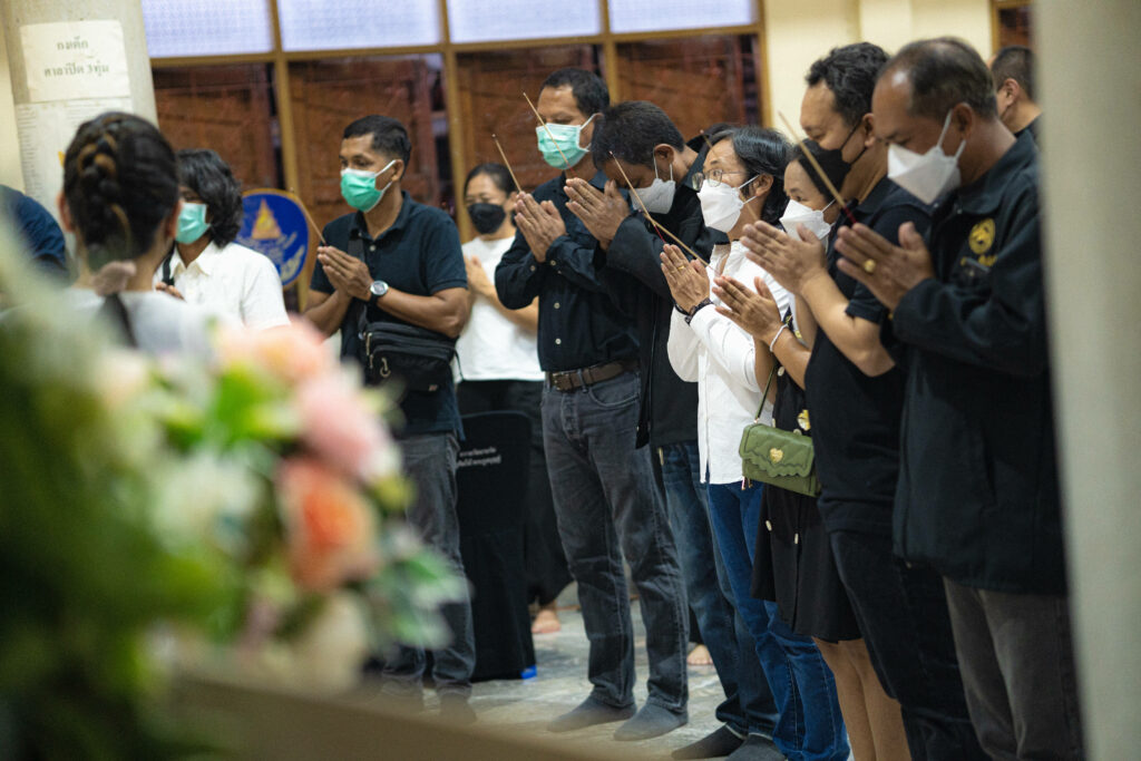 Traditional Thai Mourning Ritual: Guests Pay Respects with Incense at a Funeral Ceremony Wallpaper