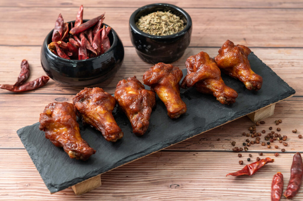 Mouthwatering Chili Chicken Wings Wallpaper: Rustic Culinary Delight