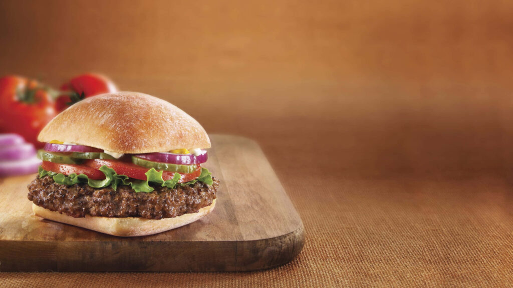 Mouthwatering Gourmet Burger on Rustic Wooden Surface - Wallpaper