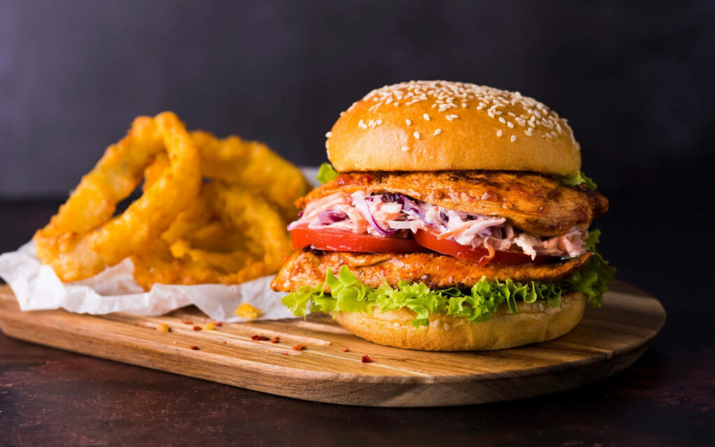 Delicious Peri Peri Chicken Burger with Crispy Onion Rings Wallpaper