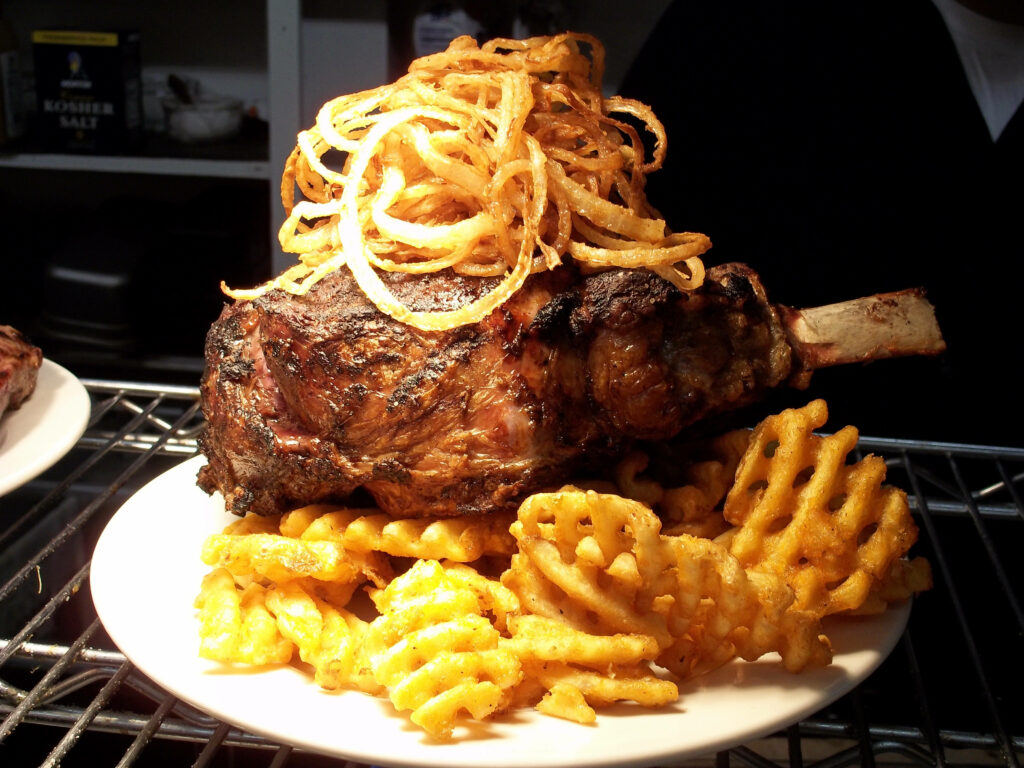 Mouthwatering Rib Eye Steak Wallpaper with Onion Rings & Waffle Fries