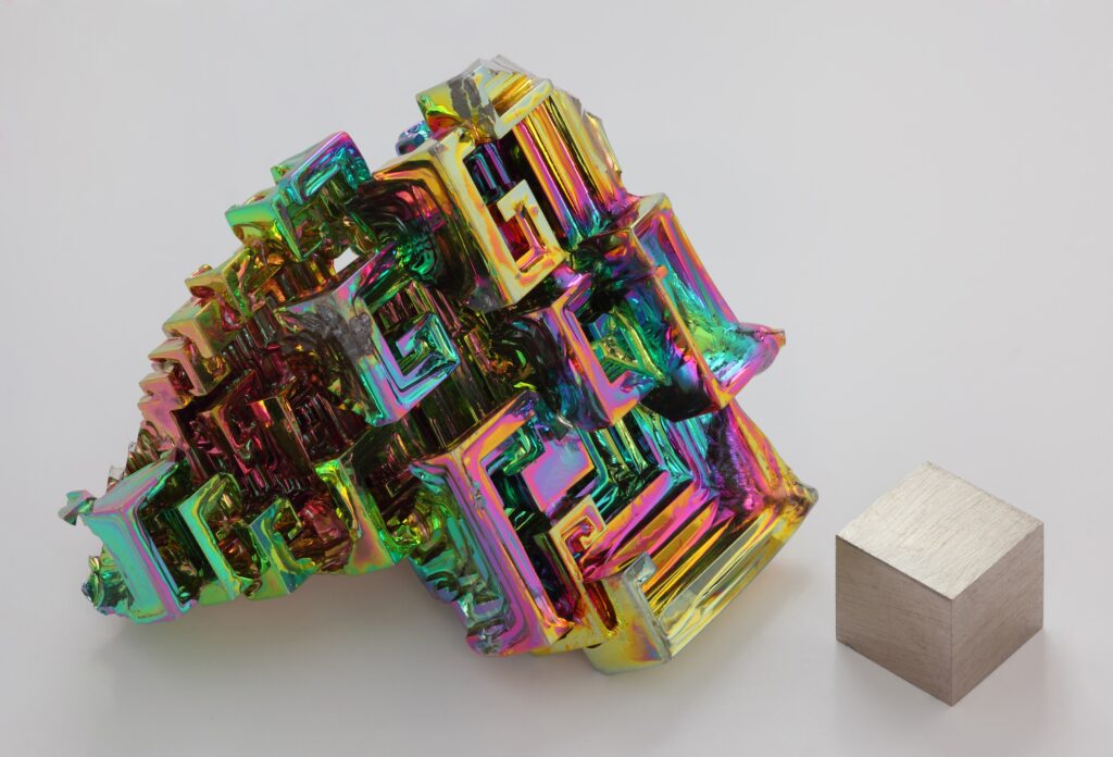 Iridescent Bismuth Crystal & Polished Metal Cube on White Background Wallpaper