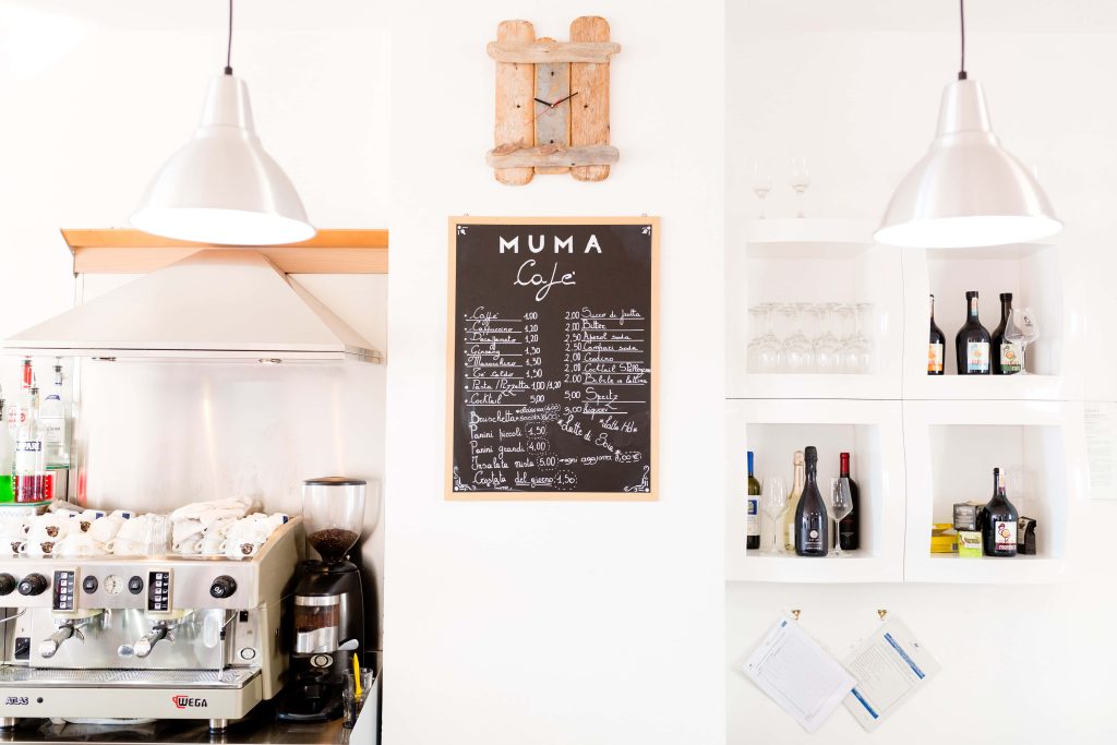 Minimalist Muma Cafe interior with chalkboard menu Wega espresso and sleek drink shelves wallpaper