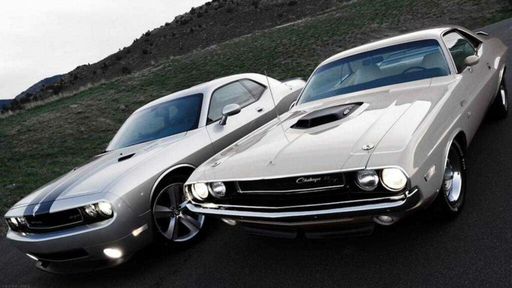 Two muscle cars parked on scenic mountain road perfect desktop wallpaper for car enthusiasts