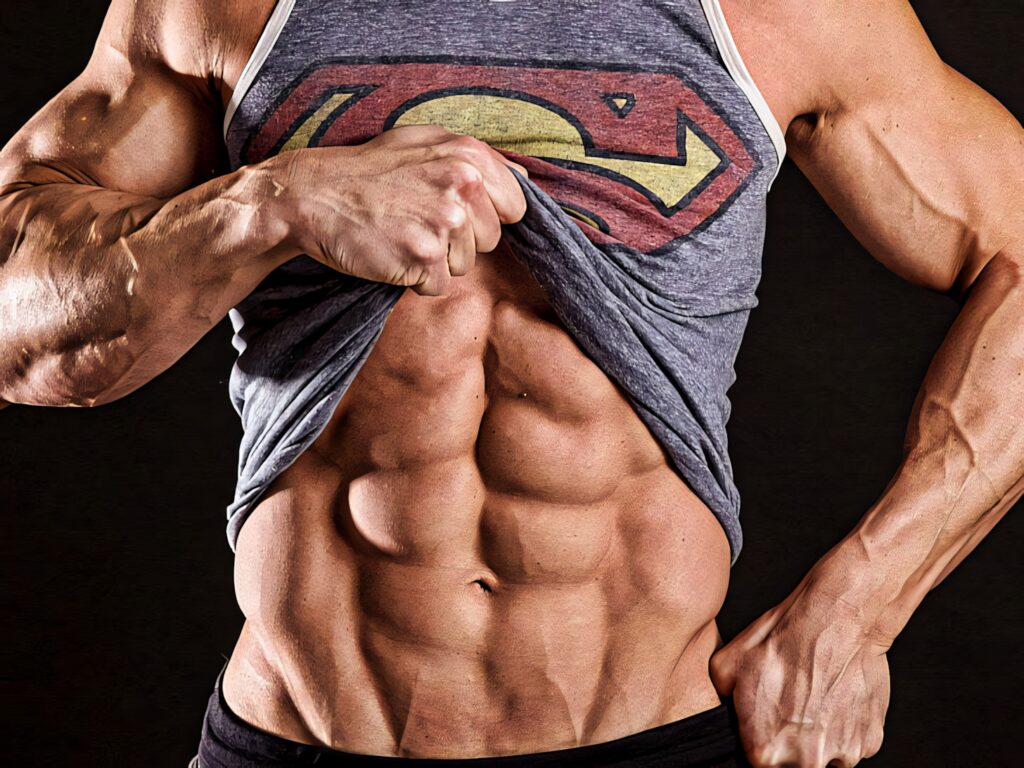 Muscular bodybuilder lifts shirt to reveal sculpted abs and Superman logo in sharp HD detail Wallpaper