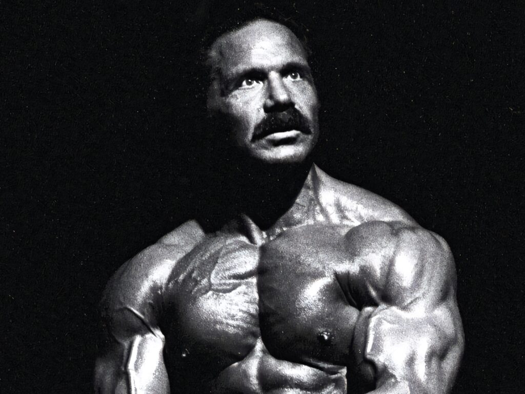 Muscular bodybuilder with stunned expression posed dramatic lighting dark background wallpaper