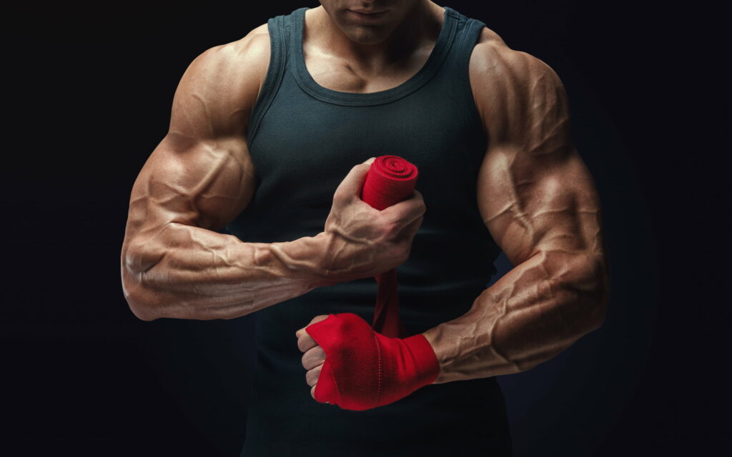Muscular Majesty: A Stunning Snapshot of a Bodybuilding Athlete's Ripped Biceps and Sculpted Muscles Wallpaper