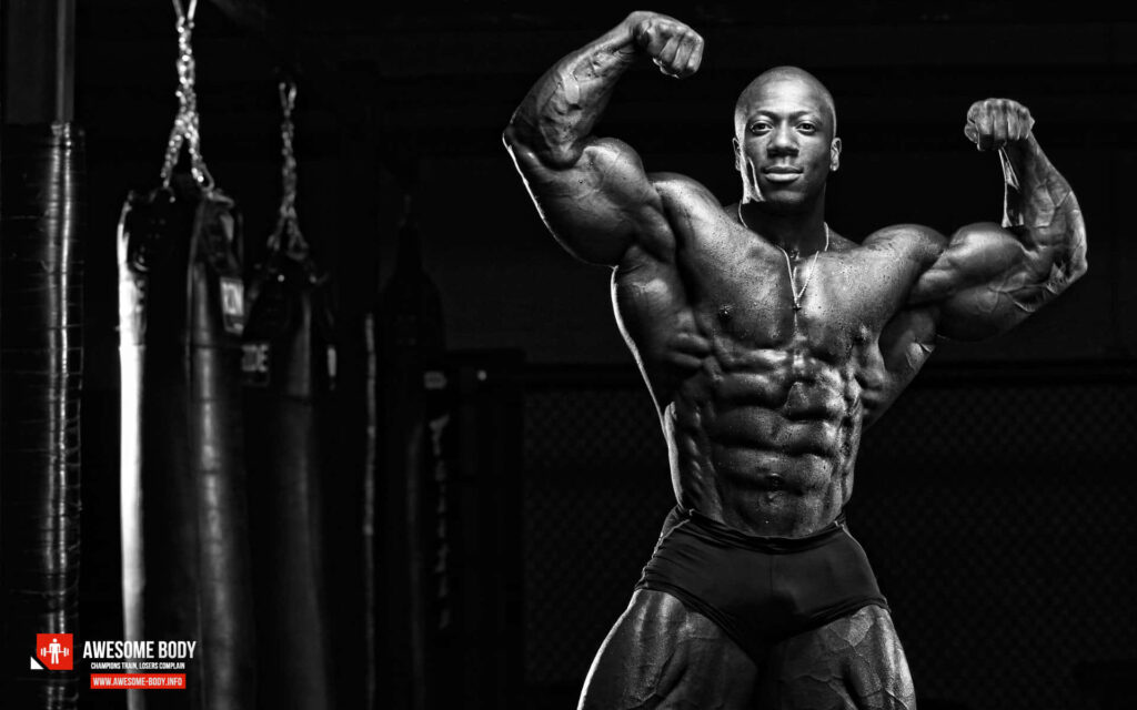 Muscular man flexing defined muscles in classic bodybuilding pose with dramatic gym lighting Wallpaper