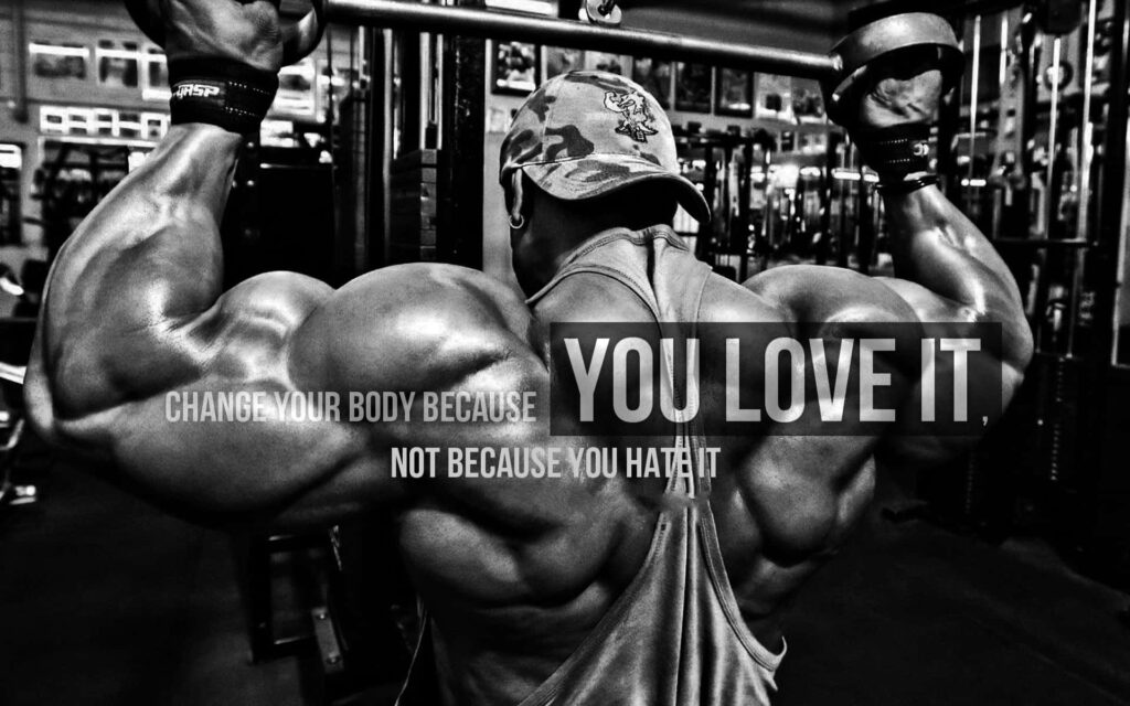 Muscular man lifting heavy weights in gym showing strength with motivational fitness quote wallpaper