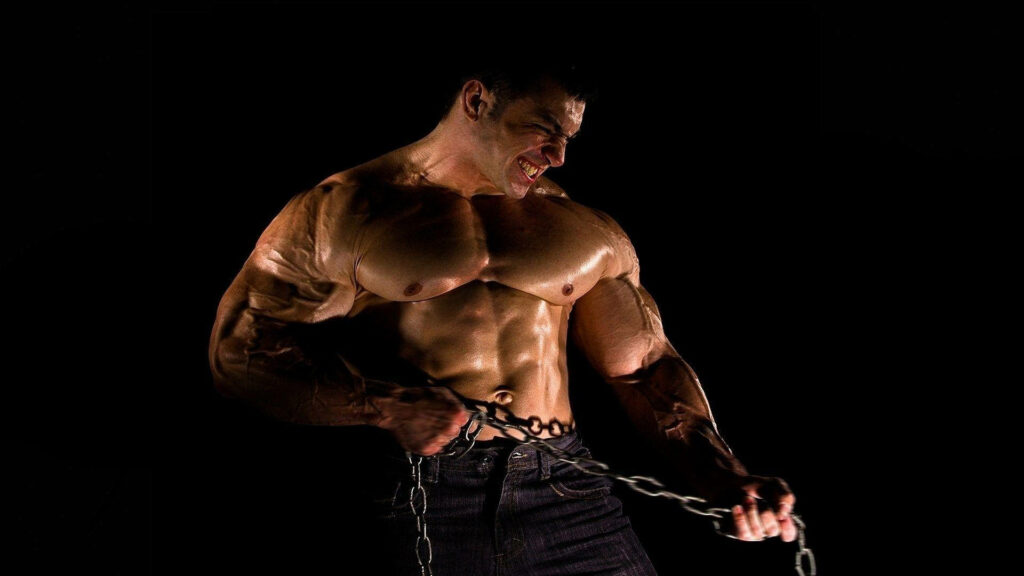 Muscular man pulling heavy chain showing intense strength and determination on black background Wallpaper