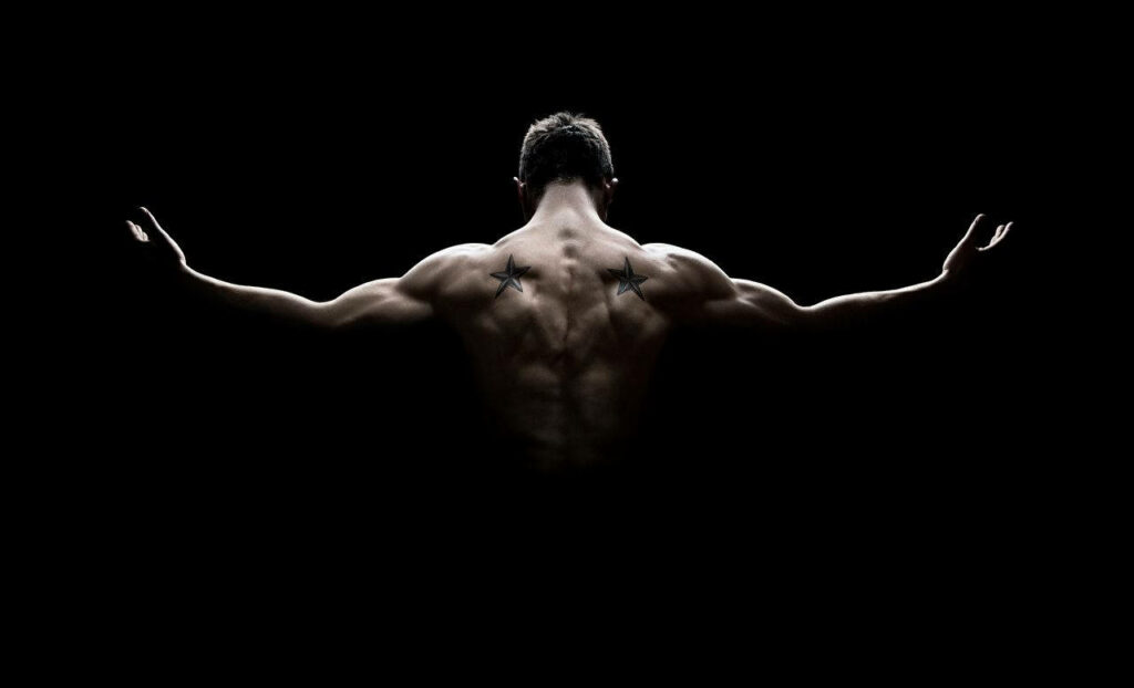Muscular Man with Star Tattoos: Strength Against Minimalist Background Wallpaper