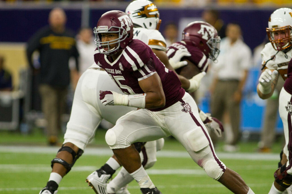 Myles Garrett running in Texas A&M football uniform on field showing power and agility action Wallpaper