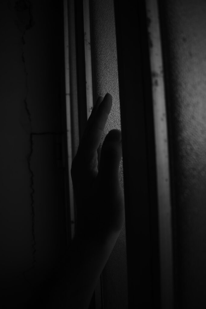 Mysterious Black & White Touch: Hand on Textured Surface in Low Light Wallpaper