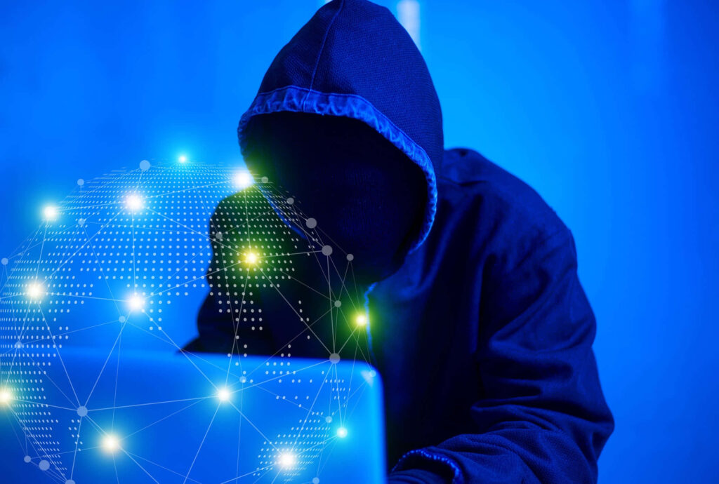 Hooded figure on laptop with glowing digital globe blue background symbolizing crypto freedom Wallpaper