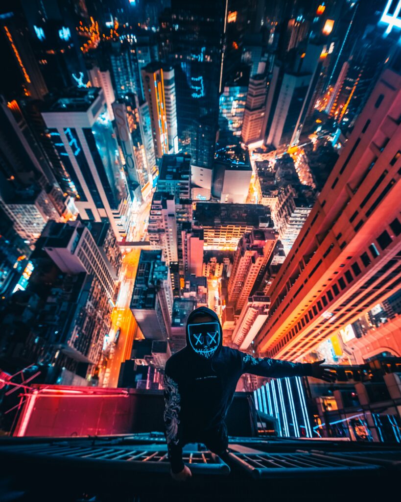 Thrilling Wallpaper of Mysterious Man Overlooking Vibrant Cityscape