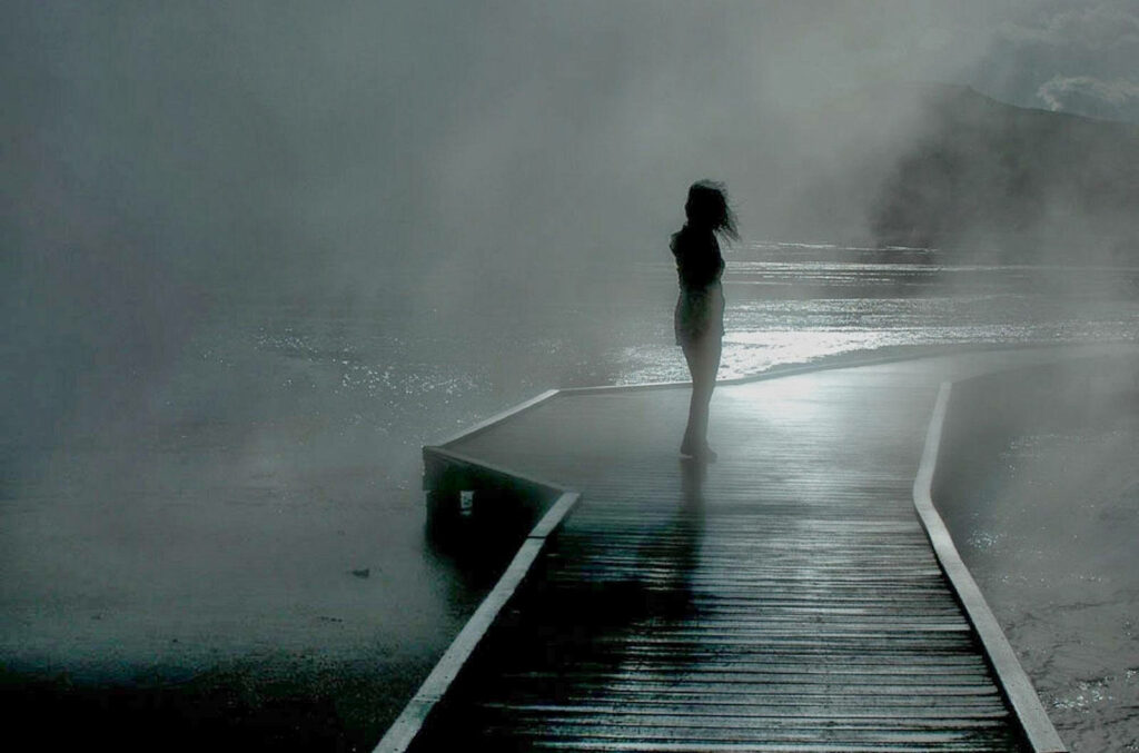 Enigmatic Reflections: A Melancholic Maiden Amidst Misty Riverside Ambiance Wallpaper