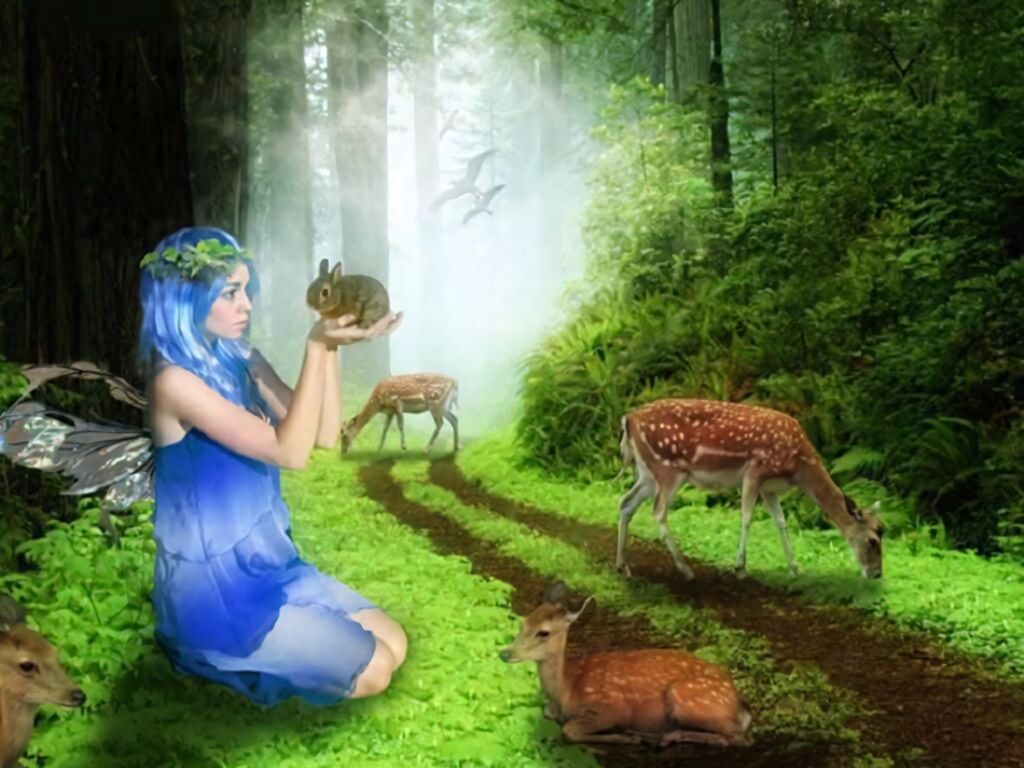 Mystical fairy with blue hair and wings holding rabbit in green forest with grazing deer and sunlight Wallpaper