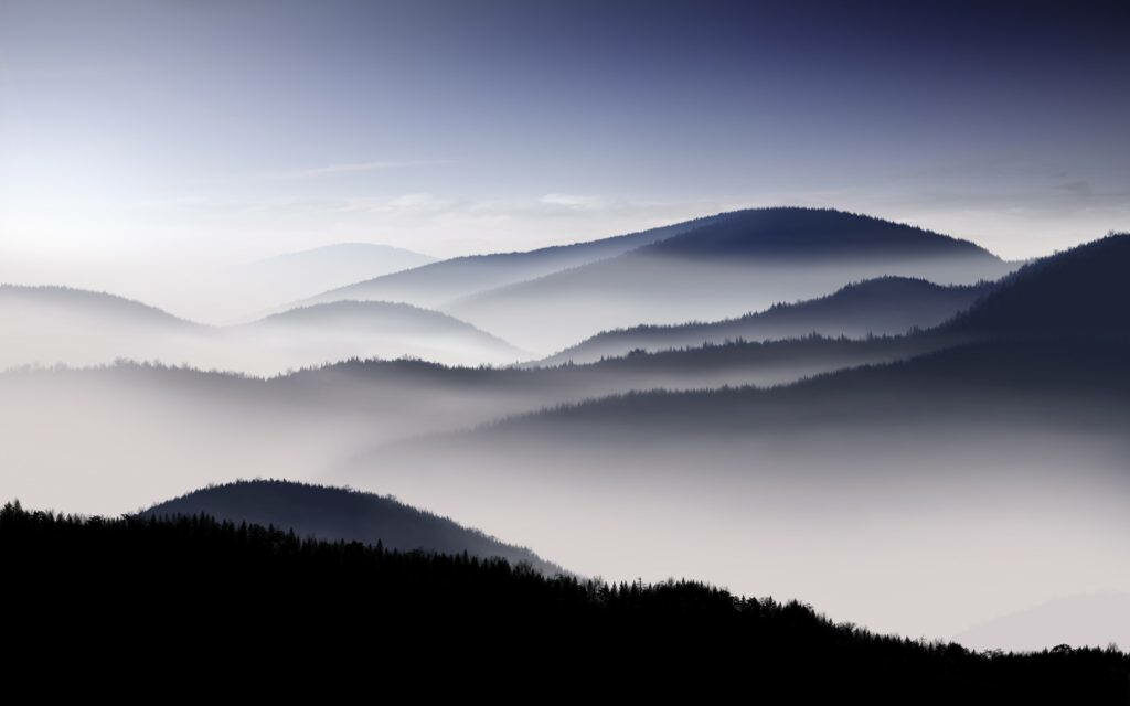 Mystical Serenity: Enchanting HD Mountain View Embraced by Mysterious Fog Wallpaper