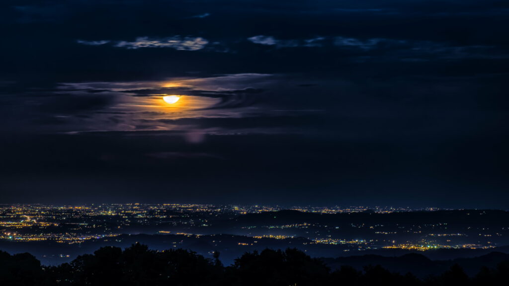 Mystical Night: Captivating Moonlit Cityscape with Enchanting Clouds Wallpaper