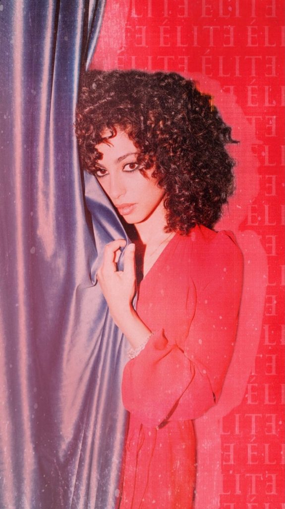 Nadia Shanaa in red dress behind purple curtain Elite Netflix wallpaper with logo background